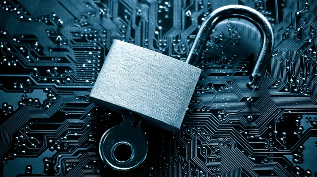 An open padlock with a key over the inner workings of a computer 