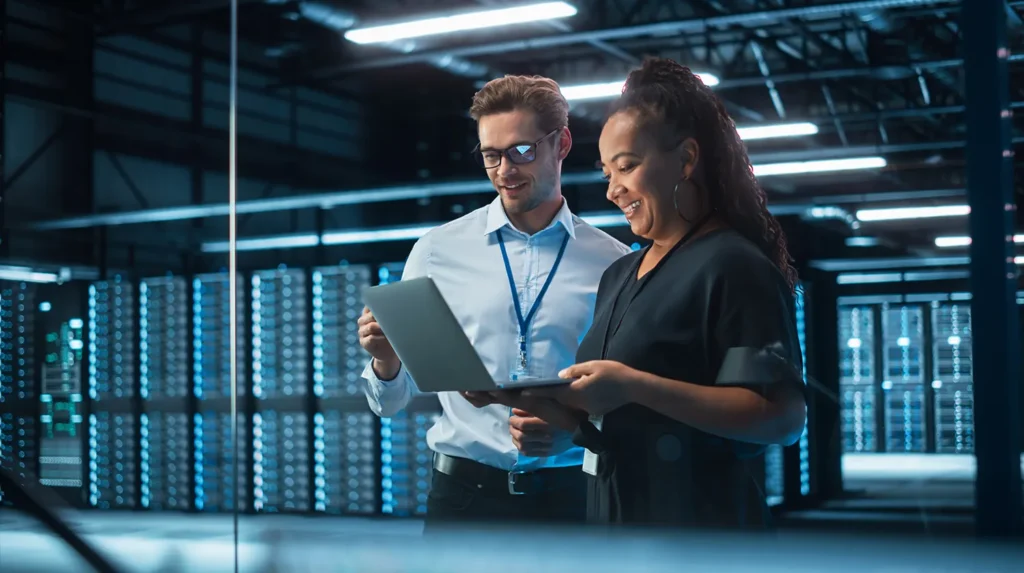a man and woman looking at a laptop