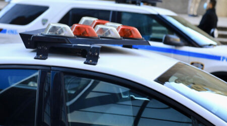Police vehicles with overhead strobe lights at a crime scene